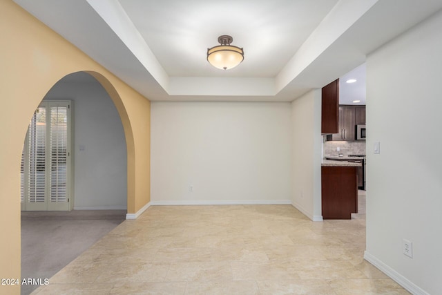 unfurnished room with a raised ceiling