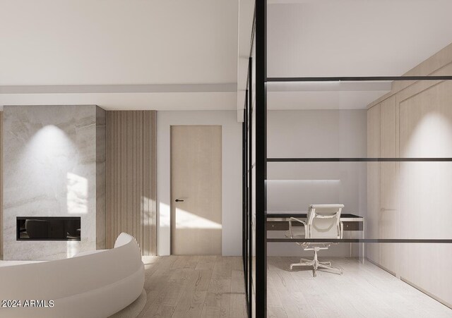 bathroom featuring hardwood / wood-style floors and a large fireplace