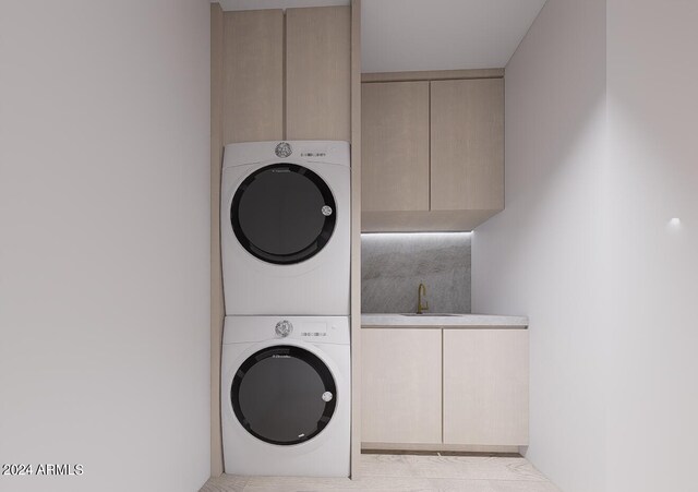 laundry room featuring stacked washer and clothes dryer, cabinets, and sink