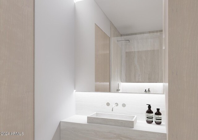 bathroom featuring a tile shower and sink