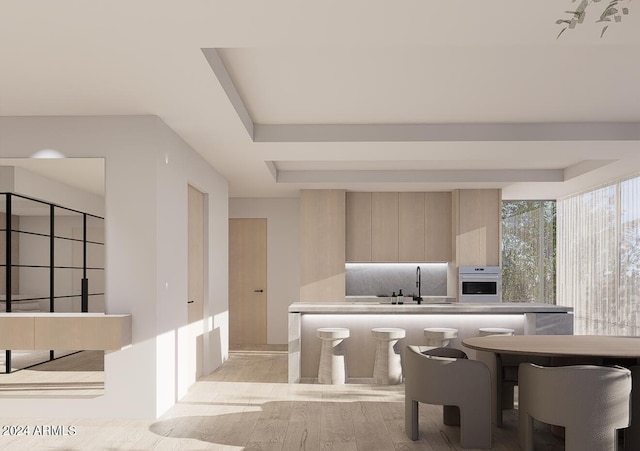 kitchen with light hardwood / wood-style flooring, oven, and sink