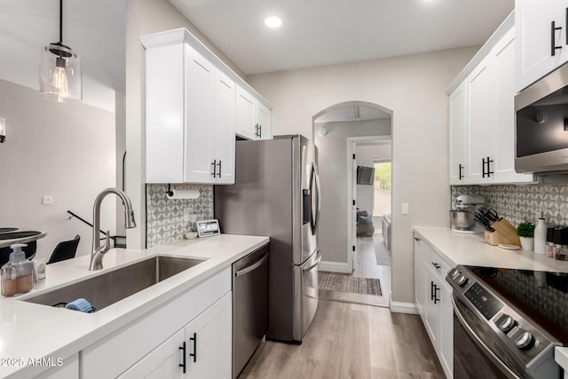 1411 E Orangewood Ave Unit 233, Phoenix, AZ 85020 - kitchen with stainless steel appliances, a sink, arched walkways, tasteful backsplash, and recessed lighting