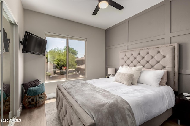 1411 E Orangewood Ave Unit 233, Phoenix, AZ 85020 - bedroom featuring wood finished floors, a decorative wall, and a ceiling fan