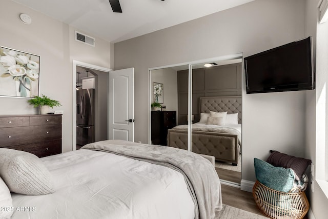 1411 E Orangewood Ave Unit 233, Phoenix, AZ 85020 - bedroom featuring stainless steel fridge, wood finished floors, baseboards, ceiling fan, and a closet