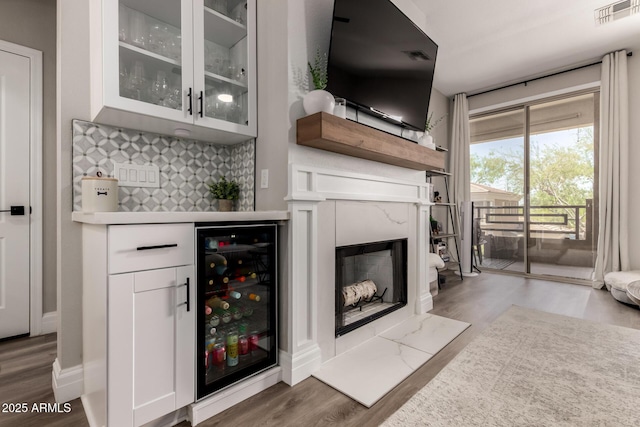 1411 E Orangewood Ave Unit 233, Phoenix, AZ 85020 - indoor dry bar featuring wine cooler, backsplash, wood finished floors, and a high end fireplace