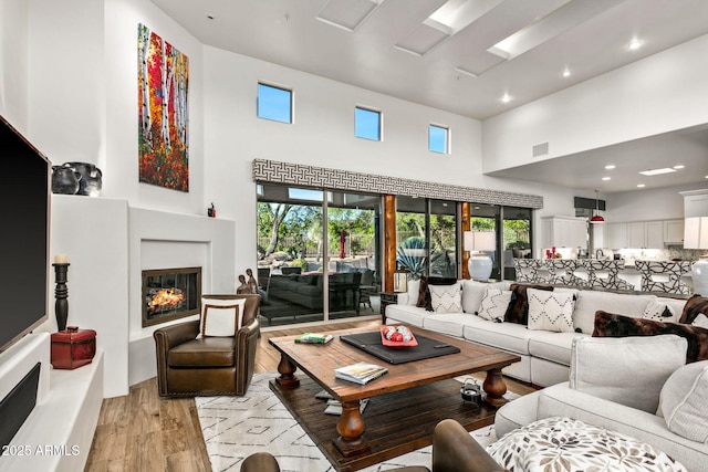 living room featuring light hardwood / wood-style flooring and a towering ceiling