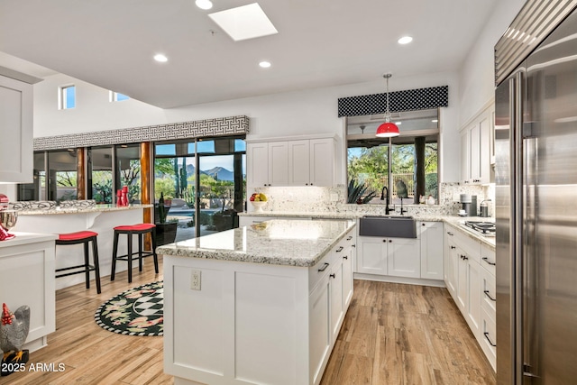 kitchen featuring sink, pendant lighting, white cabinetry, and appliances with stainless steel finishes