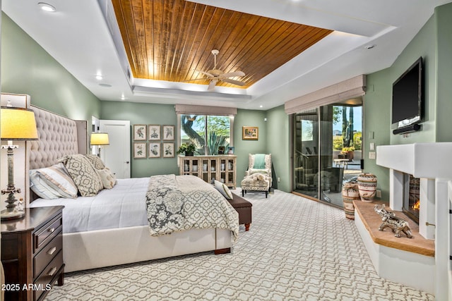 bedroom with light colored carpet, access to exterior, a tray ceiling, and wood ceiling