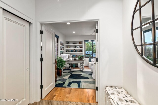 hall featuring light hardwood / wood-style floors and built in features