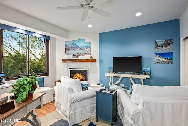 living room featuring light wood-type flooring and ceiling fan