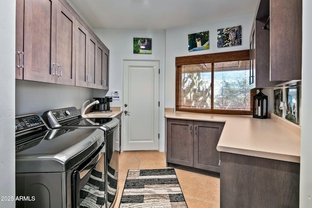 laundry area featuring cabinets, light tile patterned floors, sink, and washing machine and clothes dryer