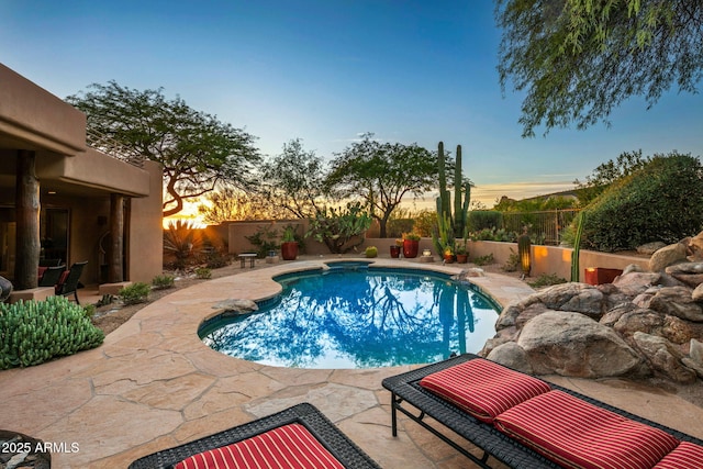 pool at dusk featuring a patio