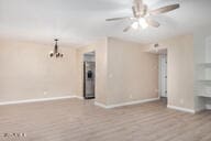 unfurnished living room with ceiling fan and light hardwood / wood-style flooring