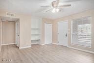 empty room with light wood-type flooring and ceiling fan