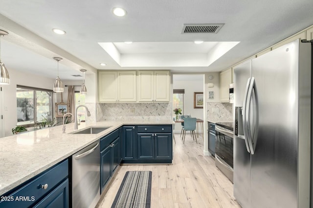 5253 E Waltann Ln, Scottsdale, AZ 85254 - kitchen featuring a sink, visible vents, a tray ceiling, stainless steel appliances, and blue cabinets