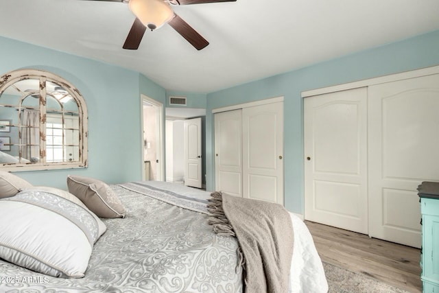 5253 E Waltann Ln, Scottsdale, AZ 85254 - bedroom featuring light wood-style flooring, ceiling fan, visible vents, and multiple closets
