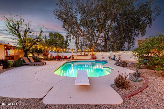 5253 E Waltann Ln, Scottsdale, AZ 85254 - pool at dusk with a fenced backyard, a fenced in pool, a patio, and a diving board