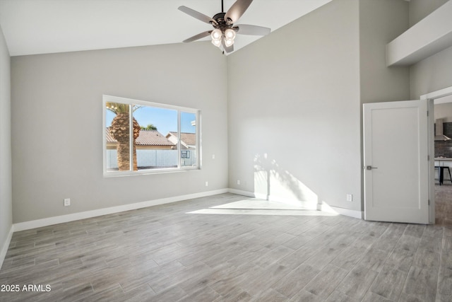 spare room with ceiling fan, high vaulted ceiling, and light wood-type flooring