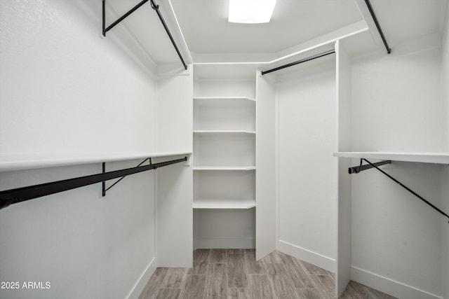 spacious closet with light hardwood / wood-style floors