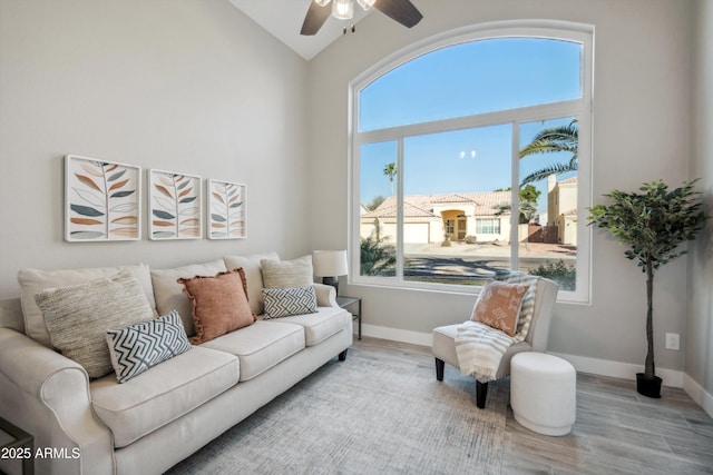 living room with ceiling fan, wood-type flooring, and high vaulted ceiling