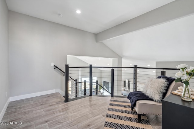 sitting room with vaulted ceiling with beams and light hardwood / wood-style flooring