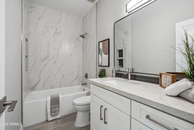 full bathroom with hardwood / wood-style flooring, vanity, toilet, and tiled shower / bath combo