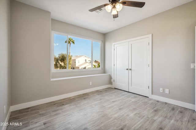 unfurnished bedroom featuring a closet, ceiling fan, and light wood-type flooring