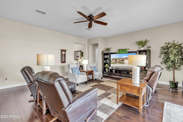 living room with a ceiling fan, visible vents, baseboards, and wood finished floors