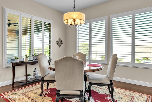 dining space with an inviting chandelier, baseboards, a wealth of natural light, and wood finished floors