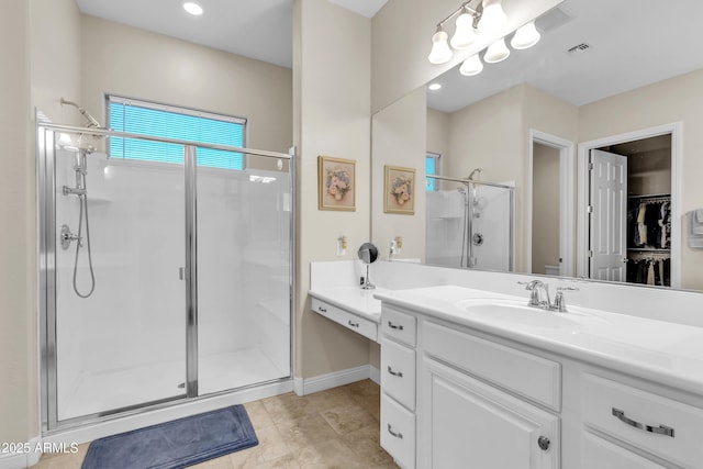 bathroom featuring a stall shower, visible vents, tile patterned flooring, a walk in closet, and vanity