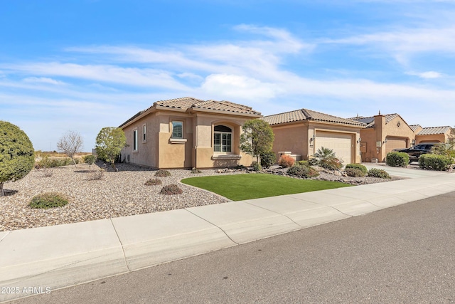 mediterranean / spanish home with driveway, a tile roof, and stucco siding