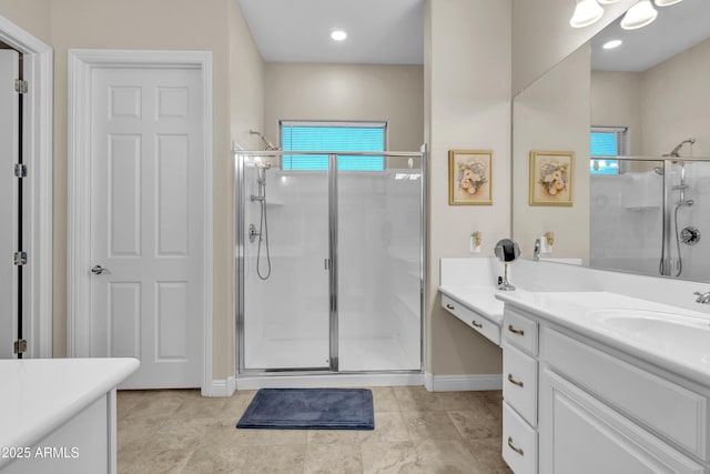 bathroom with a stall shower, vanity, and baseboards