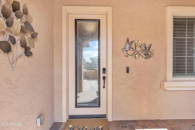 view of exterior entry featuring stucco siding