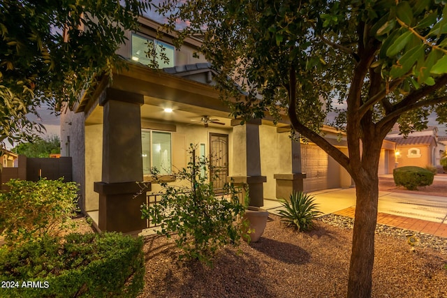 view of property exterior with a garage, stucco siding, driveway, and a ceiling fan