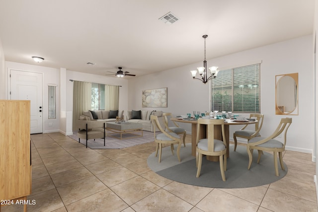 dining space featuring light tile patterned floors, visible vents, baseboards, and ceiling fan with notable chandelier