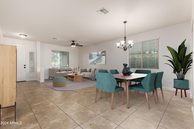 dining area featuring light tile patterned floors, visible vents, ceiling fan with notable chandelier, and baseboards