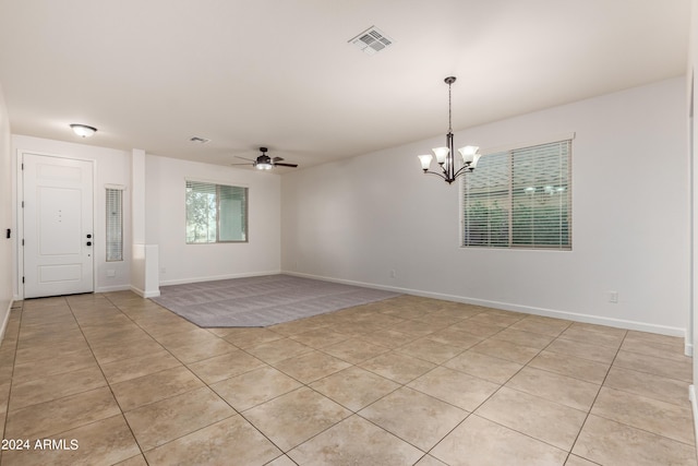 unfurnished room featuring light tile patterned floors, ceiling fan with notable chandelier, visible vents, and baseboards