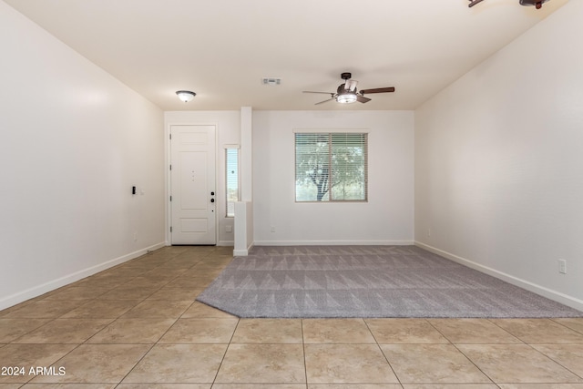 foyer featuring light tile patterned floors, a ceiling fan, visible vents, and baseboards