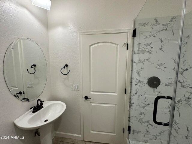 bathroom with tile patterned floors and a shower with door