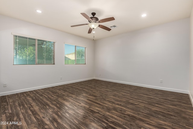 unfurnished room with dark wood finished floors, baseboards, and visible vents