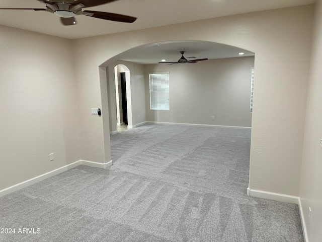 carpeted spare room featuring ceiling fan