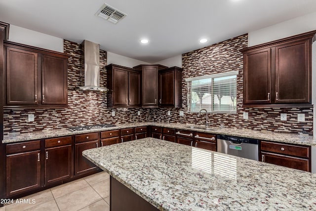 kitchen featuring visible vents, light tile patterned flooring, a sink, stainless steel appliances, and wall chimney exhaust hood