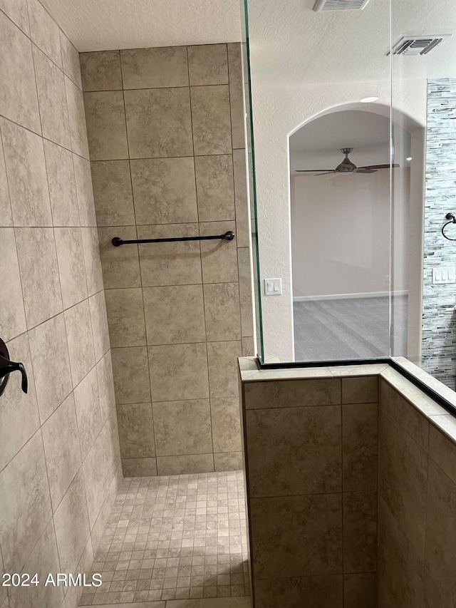 bathroom featuring tiled shower and a textured ceiling