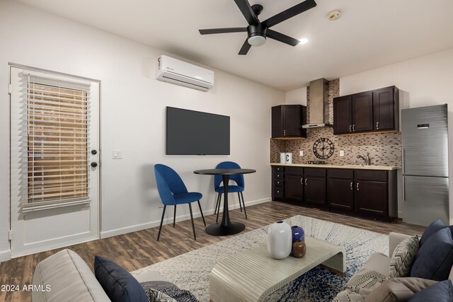 living area featuring dark wood finished floors, an AC wall unit, baseboards, and a ceiling fan