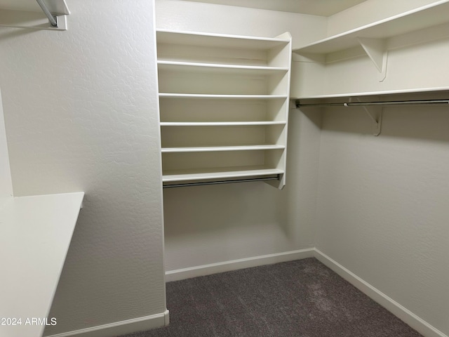 walk in closet featuring dark colored carpet