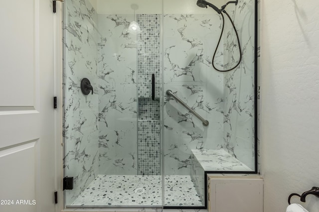 bathroom featuring a marble finish shower