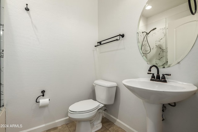 bathroom featuring tile patterned floors, toilet, a shower, and baseboards