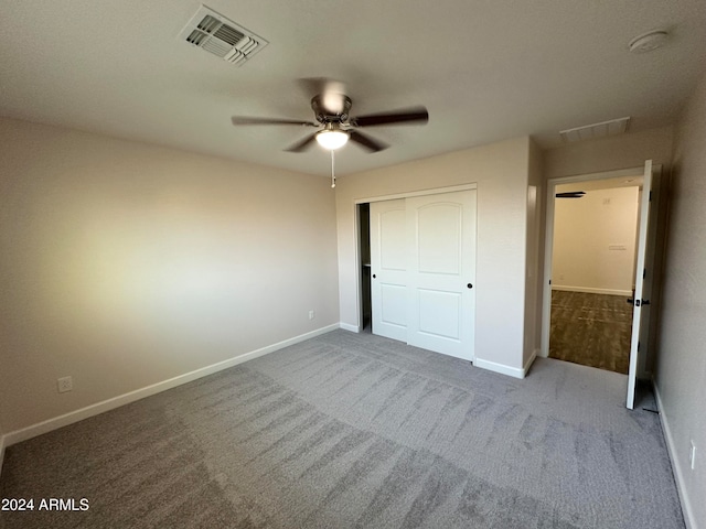 unfurnished bedroom with ceiling fan, carpet floors, and a closet