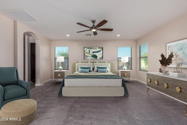 carpeted bedroom featuring visible vents, baseboards, recessed lighting, arched walkways, and ceiling fan