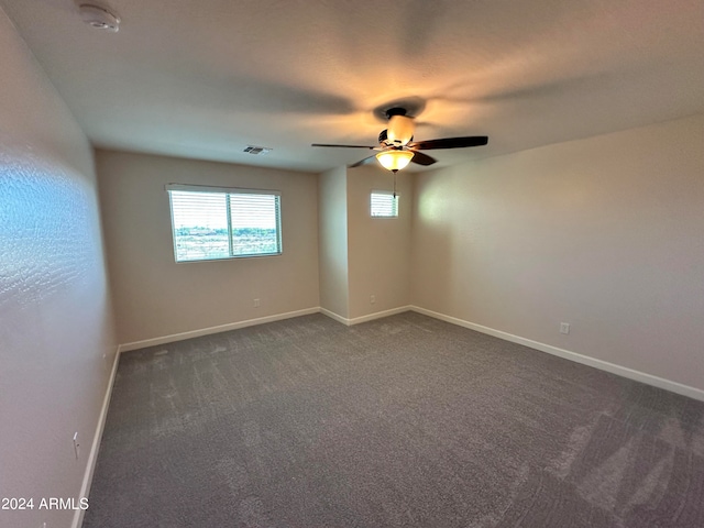 empty room featuring dark colored carpet and ceiling fan